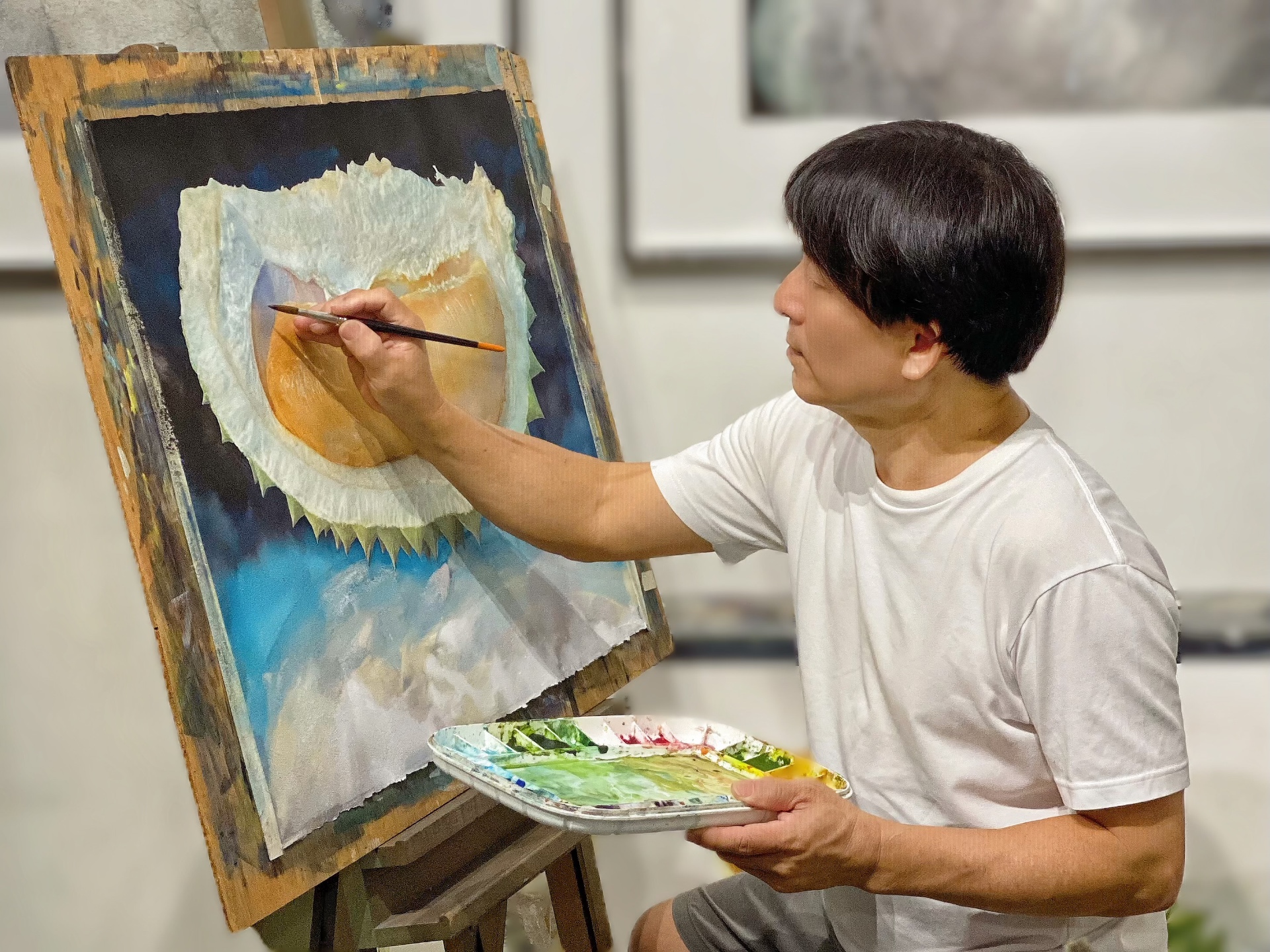 Angelo Chia Seng Chai painting a detailed watercolour of a durian on the easel