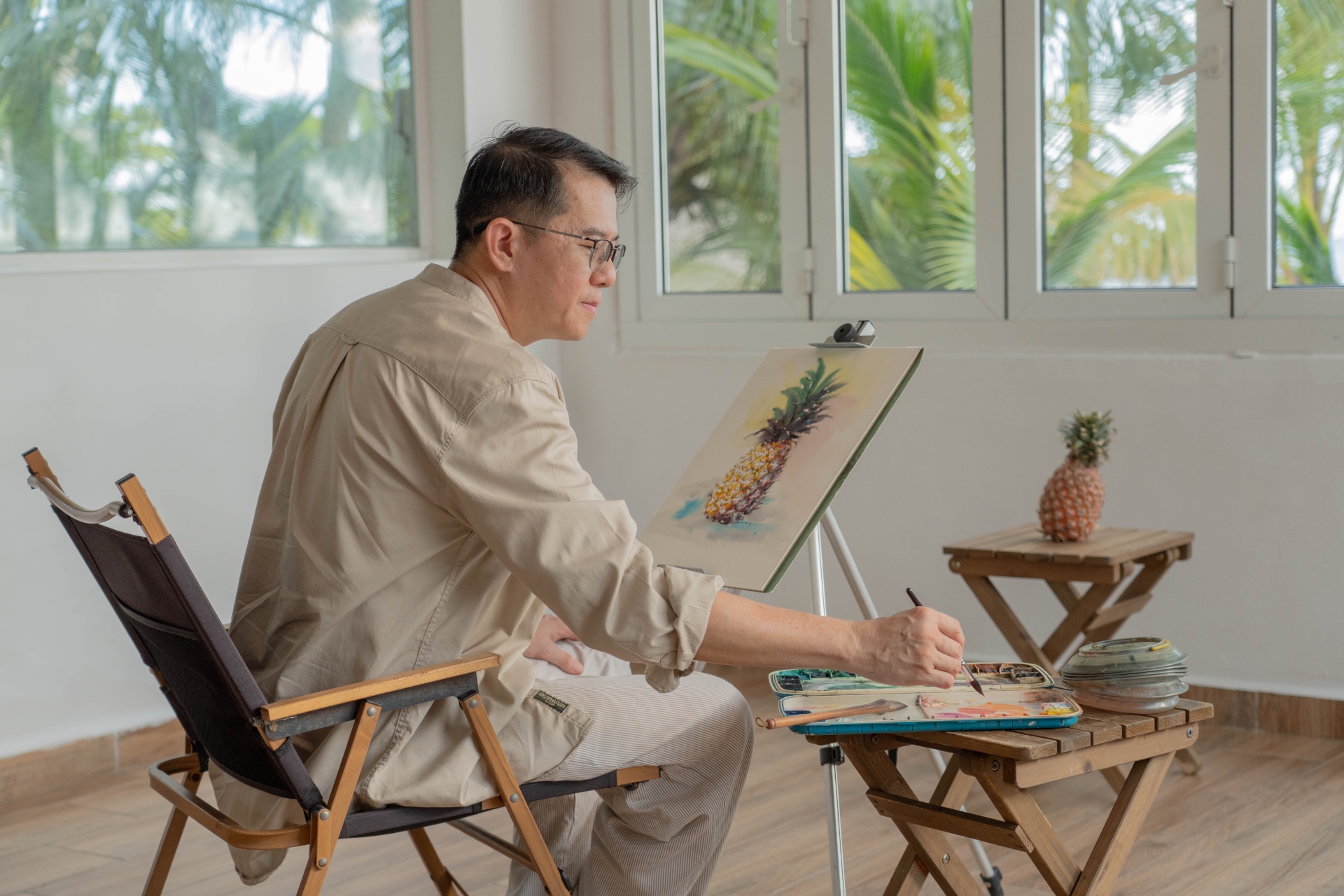 Yeo Eng Peng painting a pineapple in watercolour at his studio easel